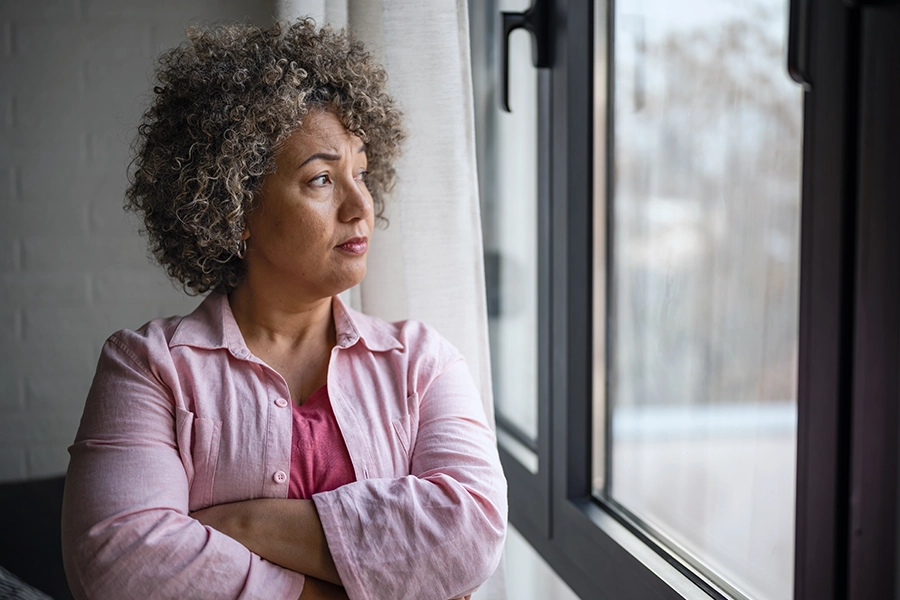 concerned woman looking out the window